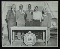Fraternities - Omega Psi Phi - Five men standing behind table (chapter unidentified)
