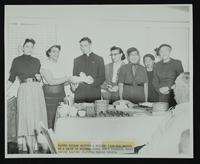 Father Keller (St. Peter Claver), Mrs. Harris, and five unidentified wom