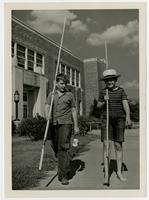 Dick Hunter and Chapin Clark with fishing poles near Pickney School