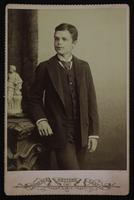 Portrait of a boy with a striped tie posing near a small sculpture