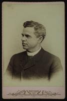 Portrait of an old man with no facial hair and a crosshatch tie
