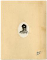 Small portrait of a woman in a floral dress framed by oval mat