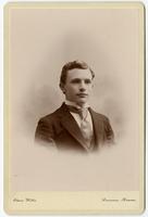 Portrait of a young man with no facial hair and a textured tie