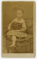 Portrait of a child on a stuffed tassled chair