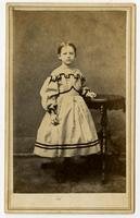 Photo of a a young girl in a white dress with black trim