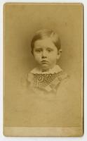 Small portrait of an infant with a white frilled collar and curvy black design