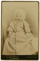 Portrait of a baby in a fuzzy white dress and a headpiece