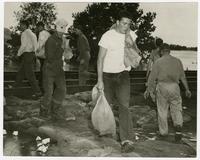 Men sandbagging by railroad tracks