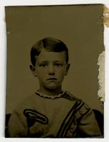 Portrait of a young boy with blushed cheeks and a top with an asymmetrical black design