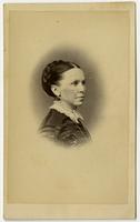 Portrait of woman with braided bun and black dangling earrings