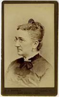 Portrait of old woman with glasses, white earrings, and haircomb