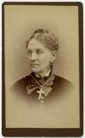 Portrait of woman with dangling earrings and large white cross necklace