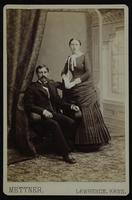 Photo of a sitting man and a standing woman