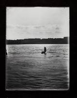 Sailboat on river with town in background