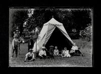 Children with toys and donkey near tent