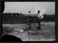 Man with measuring gauges in front of town