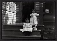 Two children on porch with toy dog