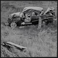 Auto wrecks - Damaged auto after rolling down embankment six miles west of Lawrence - Melvin Dale Wedel and Irene Smith, both of Burns, KS injured.