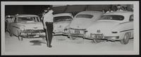 Auto accidents - Patrolman Earl Harris Inspects damage to cars/unidentified car.