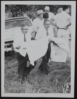 Arlis Melvin Walter is carried to ambulance by Henry Schlegel (left) and Ernie Richards.