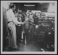 Journal World - Out of Town carriers tour. JW Building (L to R) William Metier, circulation manager; Carl Johnson, Baldwin; Eldon Brown, Desoto; Frank Huffman, Sunflower; Jimmy Ross, Perry (foreground) Wayne Ireland, Sunflower (behind) Lynn Johnson; Tonganoxie.