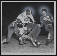 LHS v. Leavenworth - Joe Logenski (with Ball) stopped by Lawrence&#39;s (L to R) Bob Craig; Carlton Hamm; Jim Ragan.