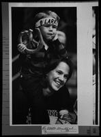 Small boy sitting on woman's shoulders