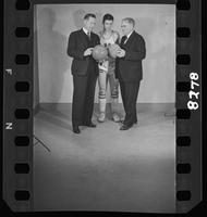Basketball Coaches "Phog" Allen and James Naismith Holding Basketballsin Front of a University of Kansas Player