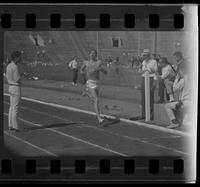 Athlete with "east" on his tank top finishing a race
