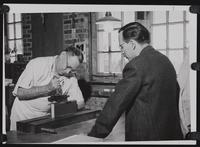 Watson Bindery workers C. Callmeyer and R. Visper operating binding equipment