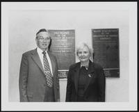 Two people standing beside University of Kansas Libraries patron and benefactor plaques