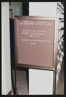 Watson Library Jim Ranz Exhibit Area announcement board for 'What's So Funny? Humor as Cultural Identity' exhibition