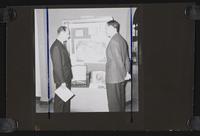 Two men examining library exhibition display case